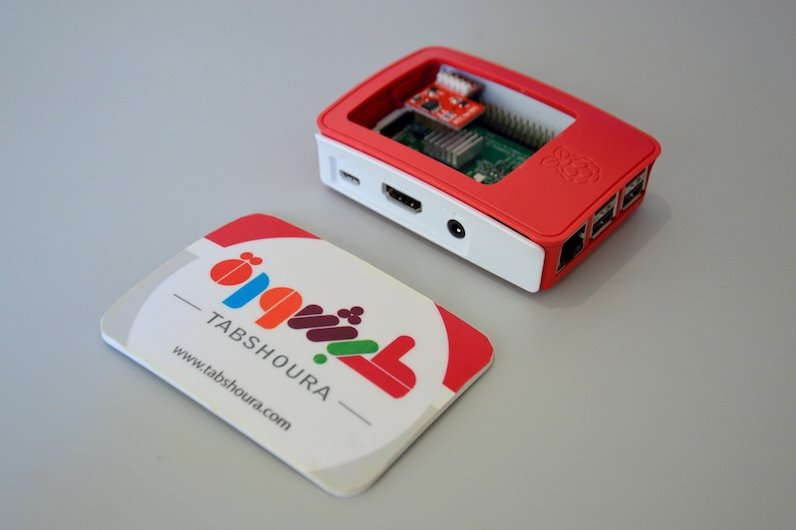 Photo: A tiny printed circuit board in an open casing, bearing the Raspberry Pi logo.