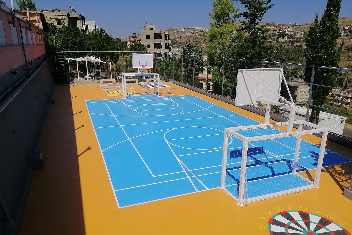 Photo: Sports grounds with a playing field, football goals and basketball nets.
