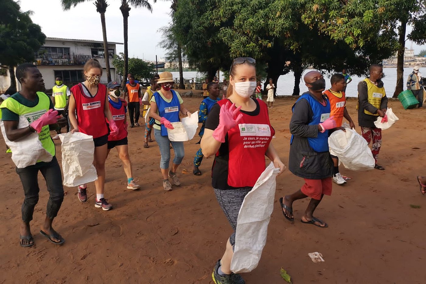 Photo: Several people hold empty white plastic bags. Some are wearing surgical masks.