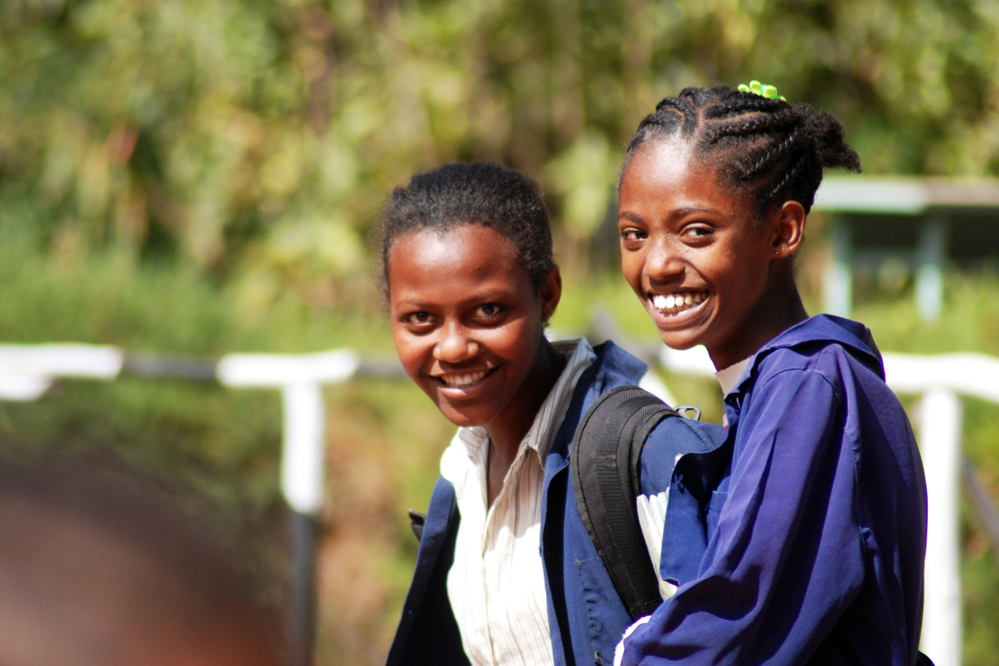 Photo: Two young people wearing similar clothes smile at the camera.