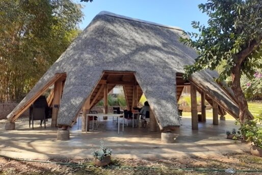 Photo: A meeting room at the GIZ office in Malawi: open wooden structure with a grass roof