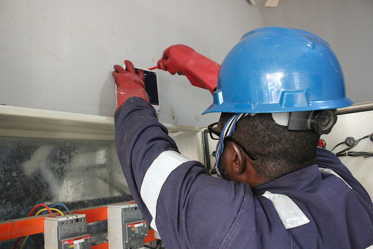 Photo: A man wearing a helmet installing an intelligent meter