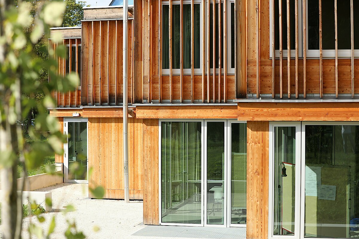 Photo: Window front of a wood-panelled building.