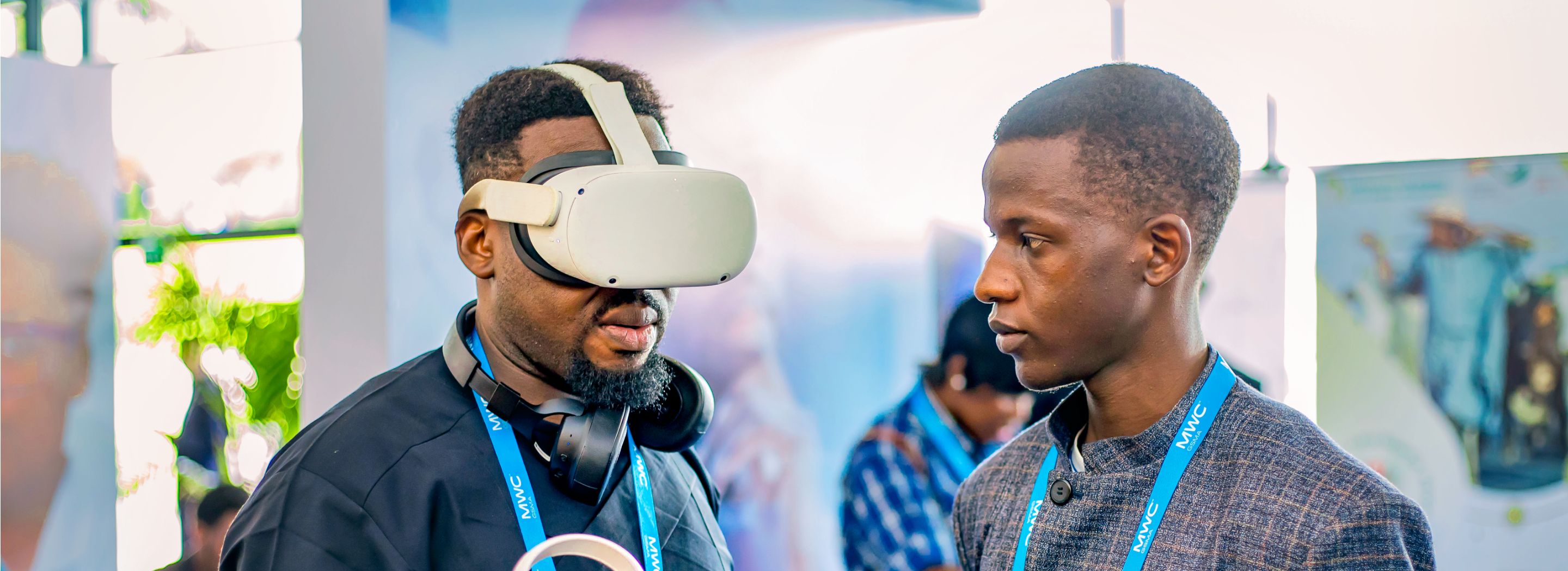 Photo: Two men standing face-to-face. The man on the left is wearing a VR headset.