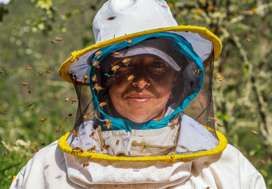 Photo: A woman in a beekeeping suit.