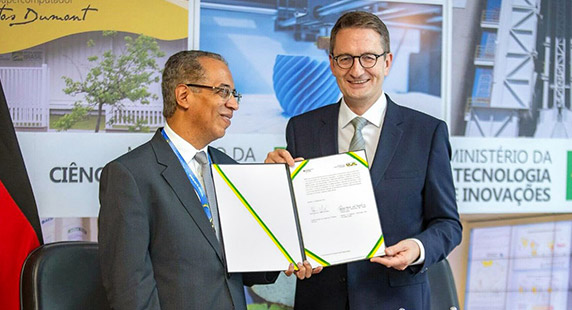 Photo: Two men holding a signed document.