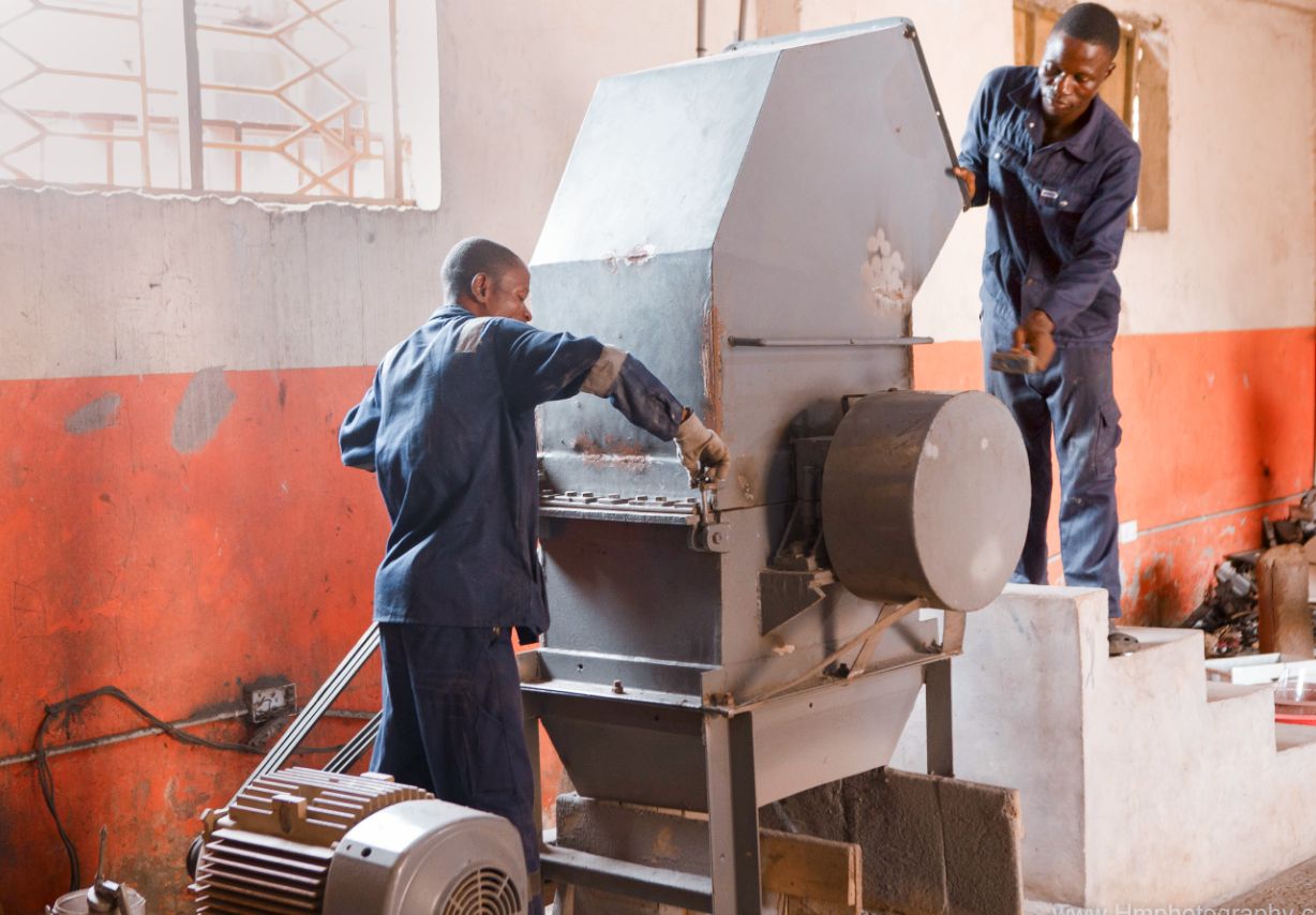 Photo: Two men working at a machine.