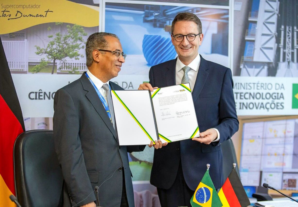 Photo: Two men holding a signed document.