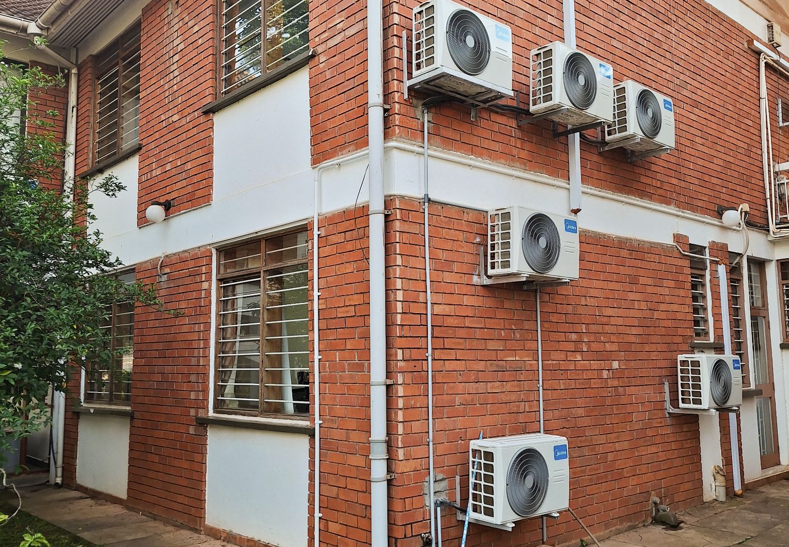 Photo: A brick building viewed from the outside, with air conditioning units.